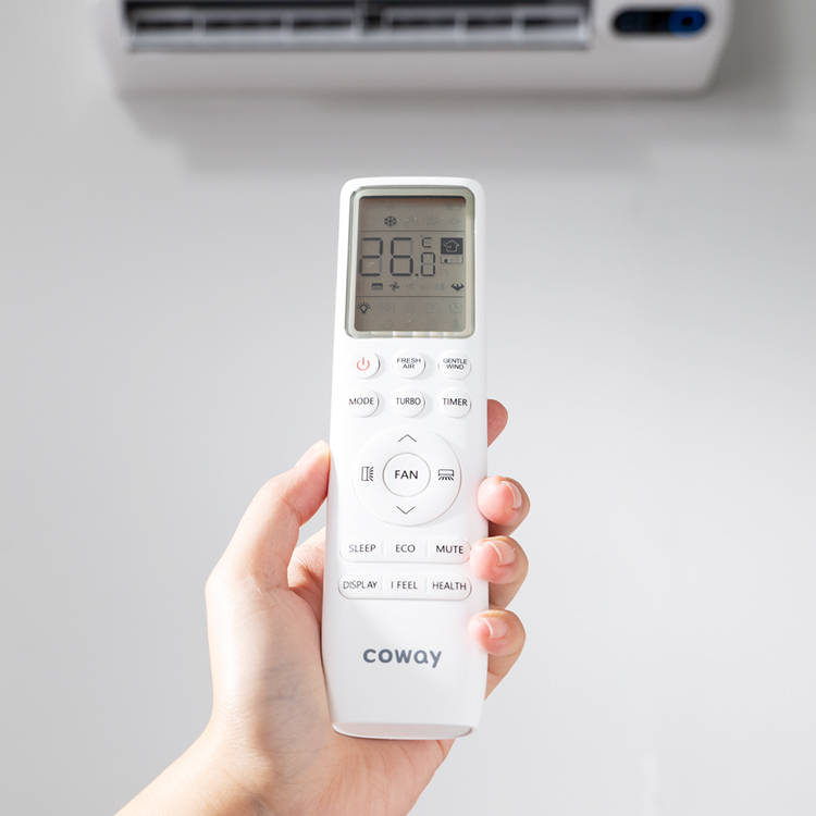 Hand holding the Coway air conditioner remote