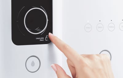 A finger holding the child safety lock on the Coway Ombak