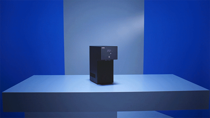 Coway Dazzie water purifier on a platform in a vivid blue studio set
