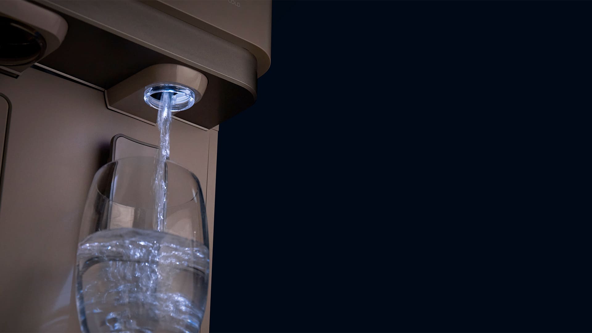 The Coway Lucy Plus dispenser filling a glass under a soft dispenser light